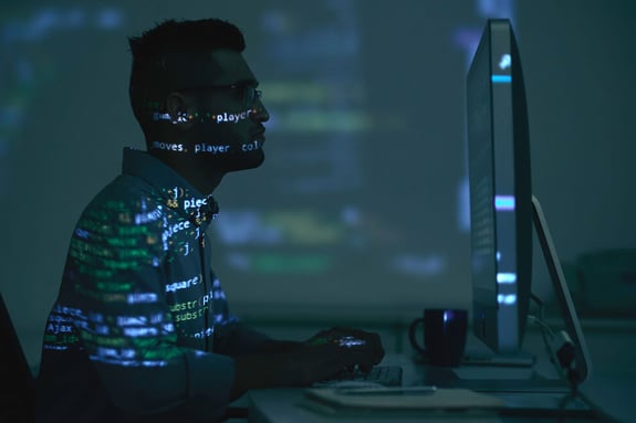 Man using intense coding on his computer. He appears to have a low mood.